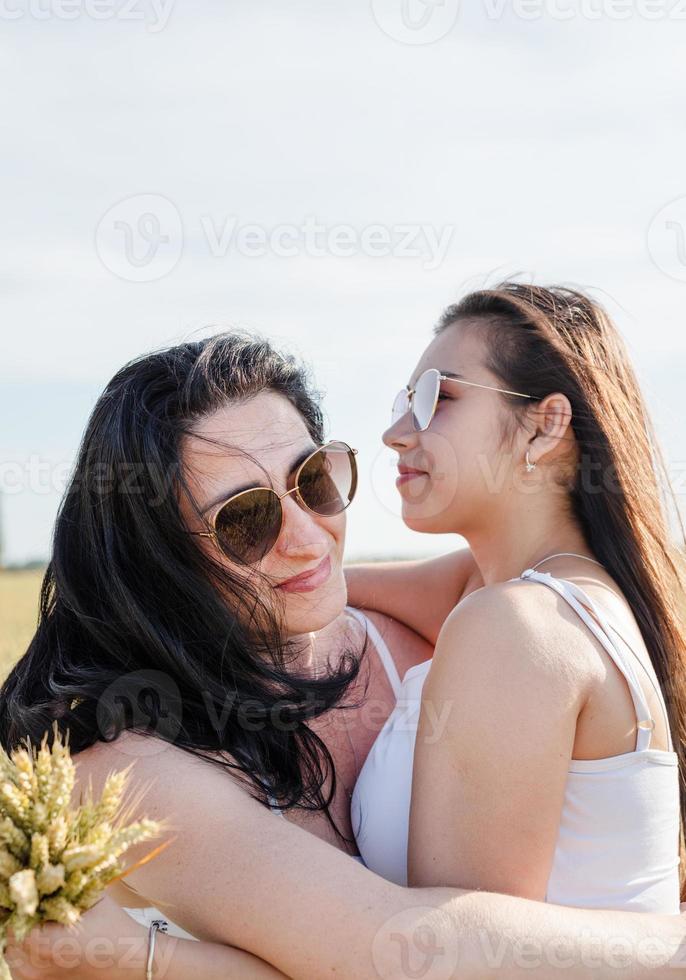 två leende kvinnliga vänner i vetefältet foto