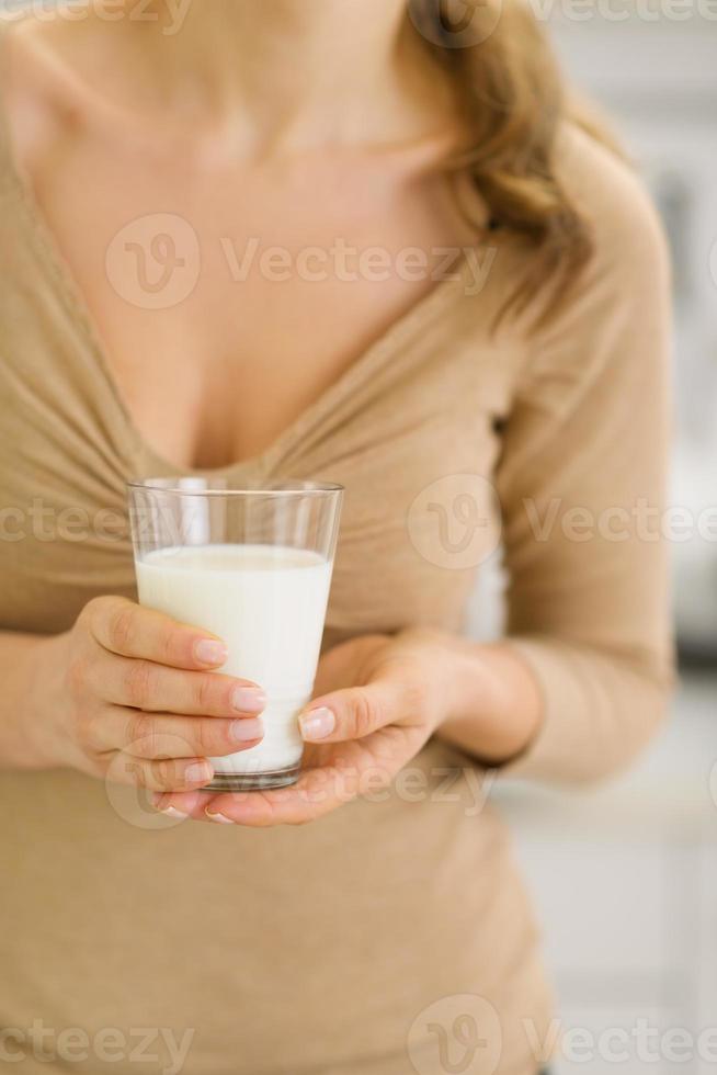 ung kvinna med glas mjölk i händerna. närbild foto