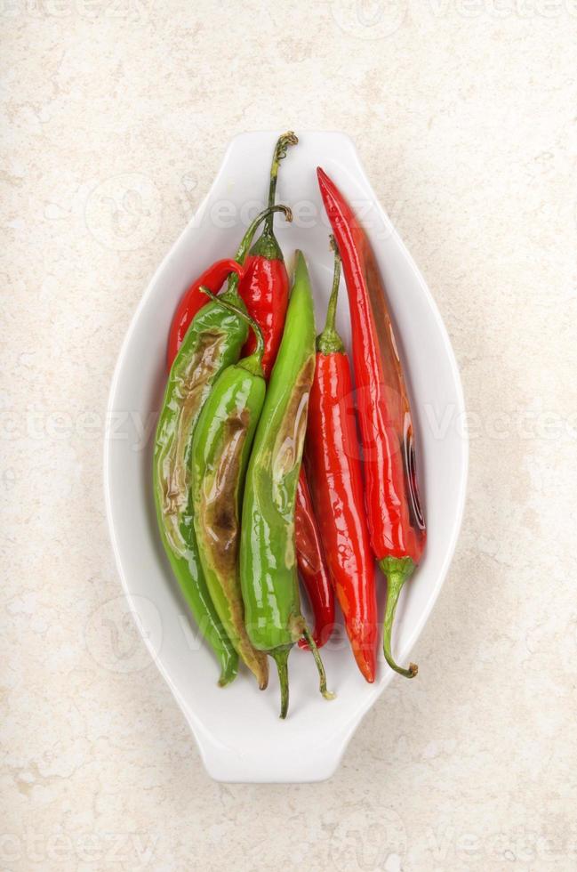grillad grön och röd chili i en skål foto