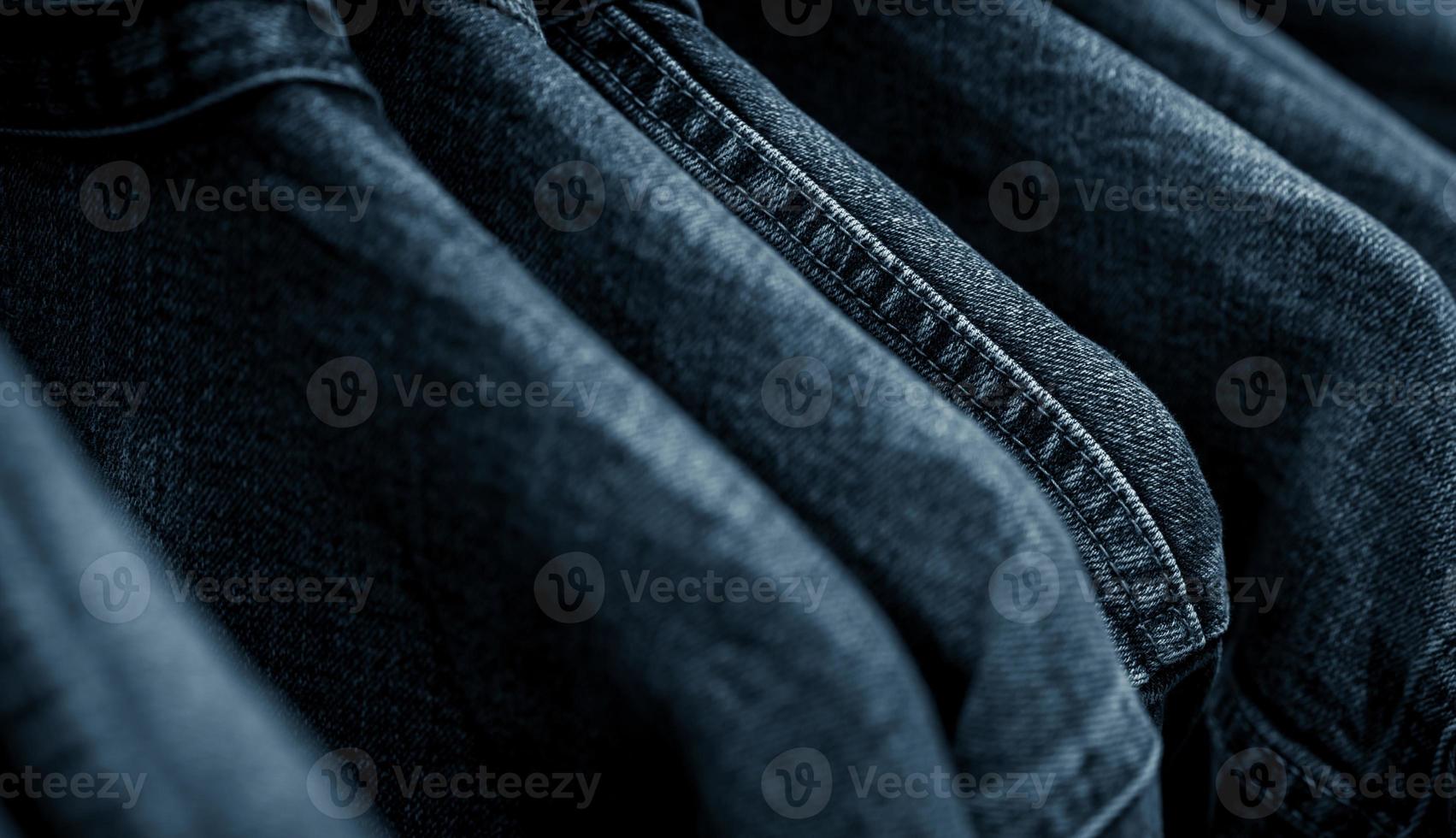 selektivt fokus på jeansjacka som hänger på ställ i klädaffär. jeans med jeansmönster. textilindustrin. jeans mode och shopping koncept. klädkoncept. jeansjacka på ställ säljes. foto