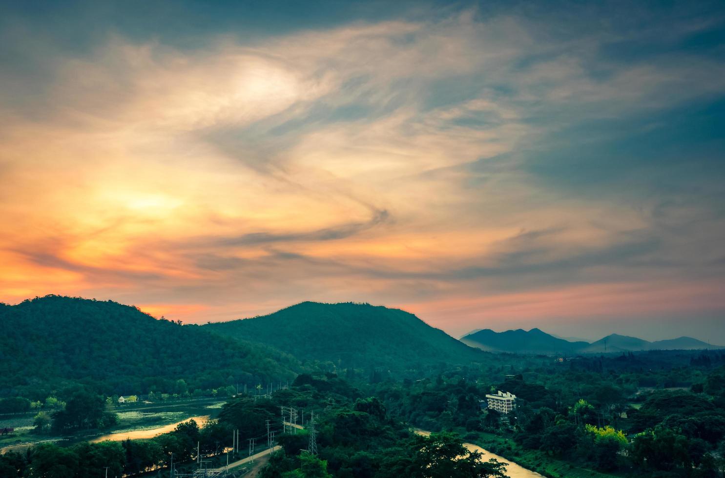 vackert naturlandskap av bergskedja med soluppgångshimmel och moln. stad i bergsdalen i thailand. landskap av bergslager med morgonsoluppgång. tropisk skog. natur bakgrund. foto