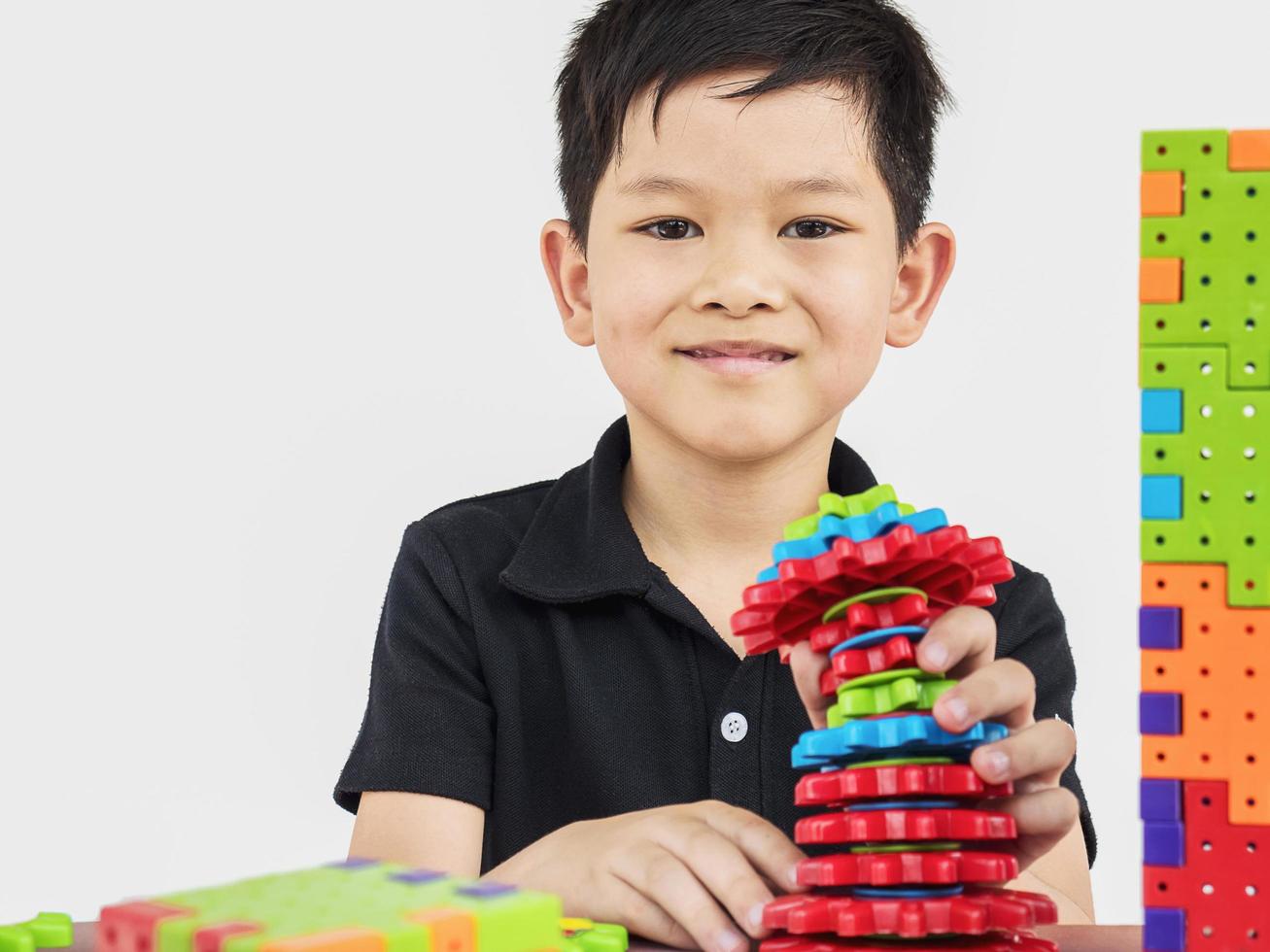 asiatiska barn spelar pussel plastblock kreativt spel för att öva sin fysiska och mentala skicklighet foto