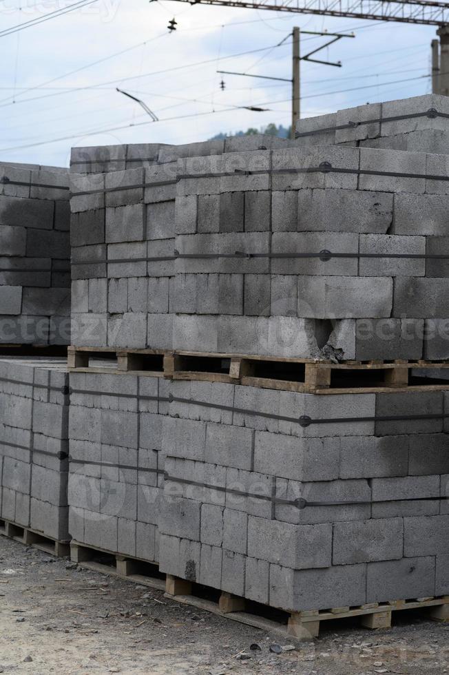 vitt tegel för konstruktion. askeblock staplade på pallar köptes in för att bygga ett hus på landsbygden. foto