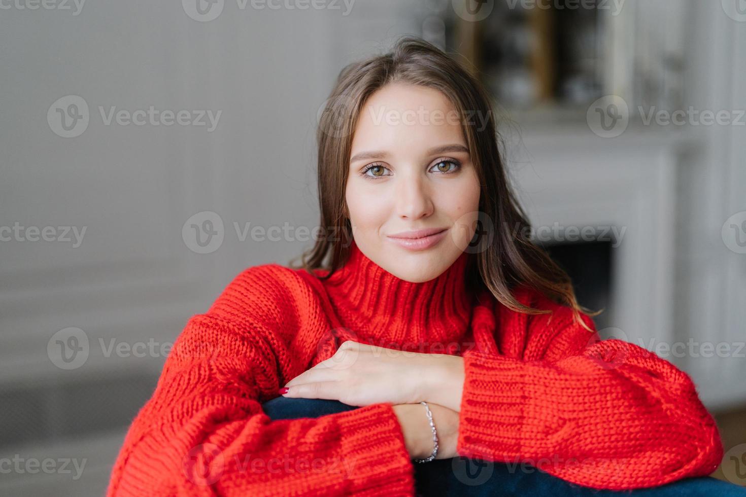 skott av en trevlig ung brunett flicka har god vila hemma, tittar direkt på kameran, har frisk hud, tillbringar ledig tid i en inhemsk atmosfär ensam. människor, skönhet, fritidskoncept foto