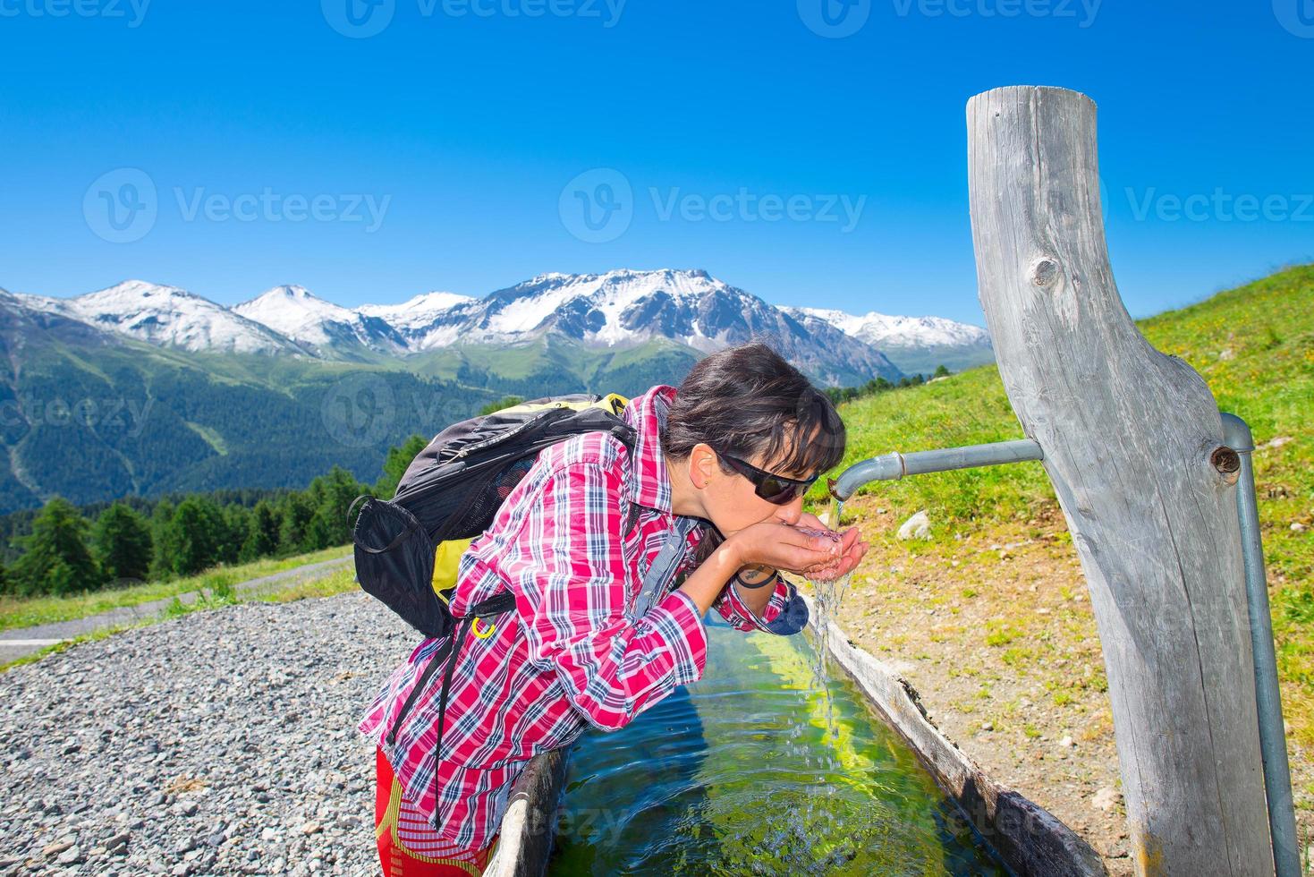 flickavandrare släcker törsten vid fontänen under en bergsvandring foto