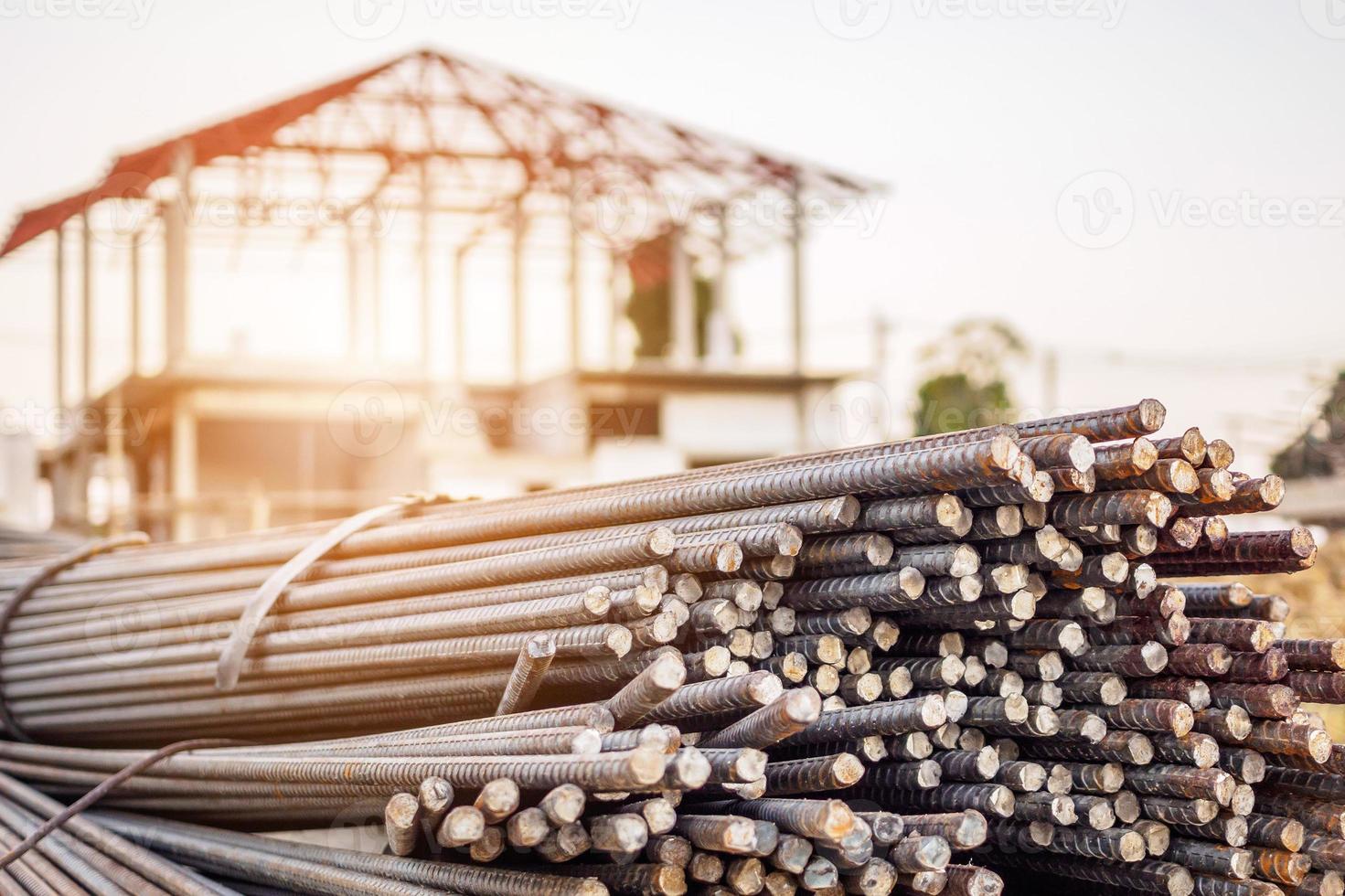 stålarmeringsjärn för armeringsbetong på byggarbetsplatsen med hus under konstruktion bakgrund foto
