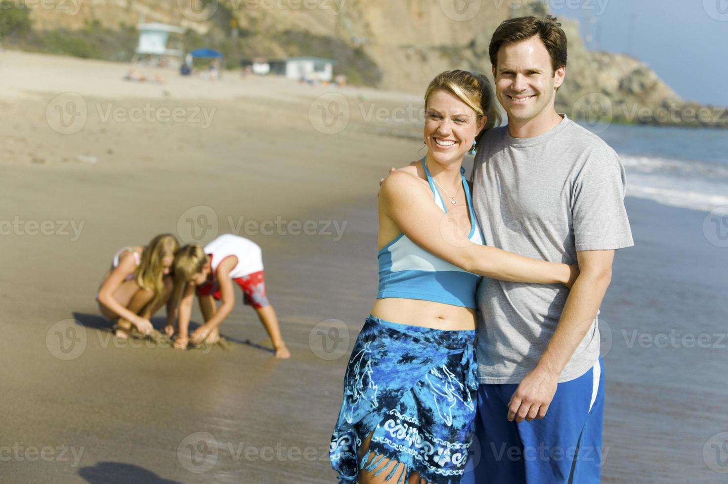 par med familjen njuter av stranden foto