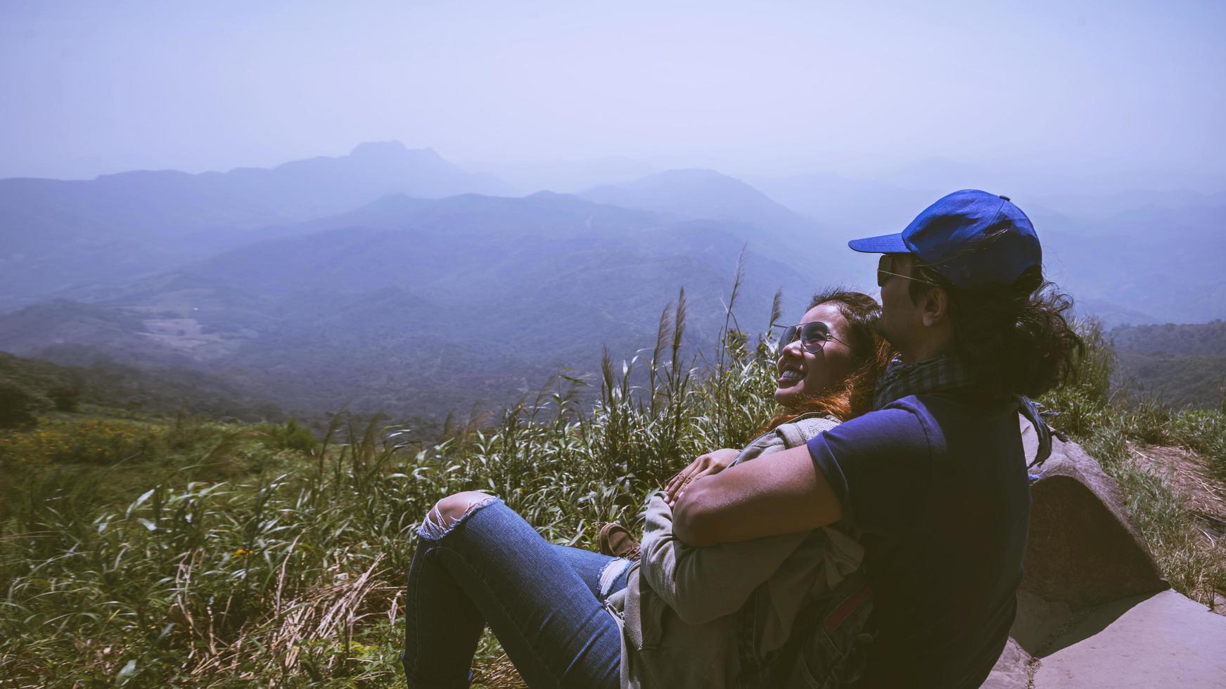 älskare kvinnor och män asiater reser koppla av i semestern. sitta och titta på landskapet på fjället. bergsparken glatt. i Thailand foto