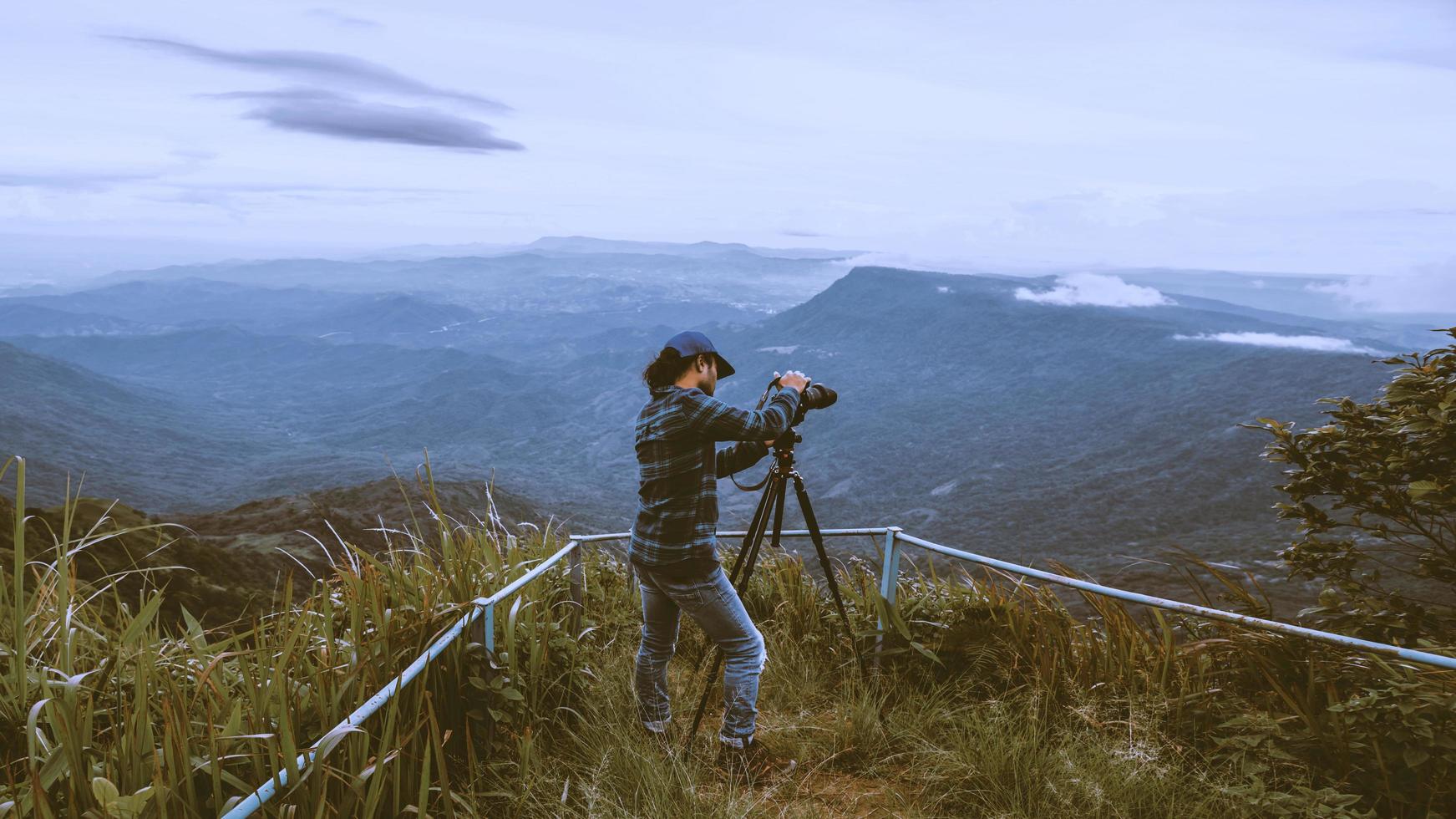 man asiater reser koppla av i semestern. fotografera landskap på mountain.thailand foto