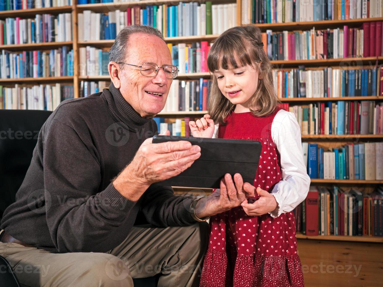 farfar och barnbarn tittar på en surfplatta foto