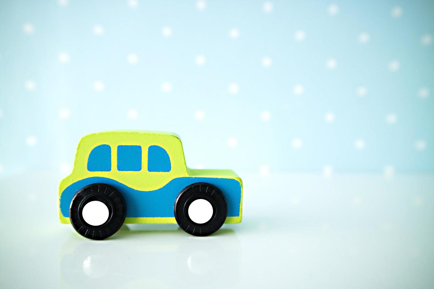 trä bilar leksaker på blå prickiga bakgrund. foto