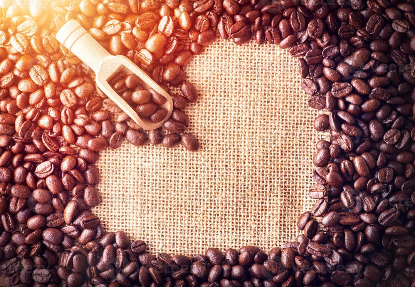 skopa på kaffebönor arrangerade som en hjärtform på påsebakgrund foto