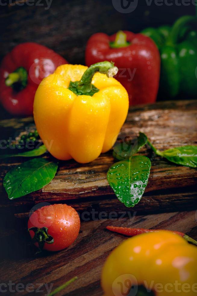 paprika med grönsaker på det gamla trägolvet foto