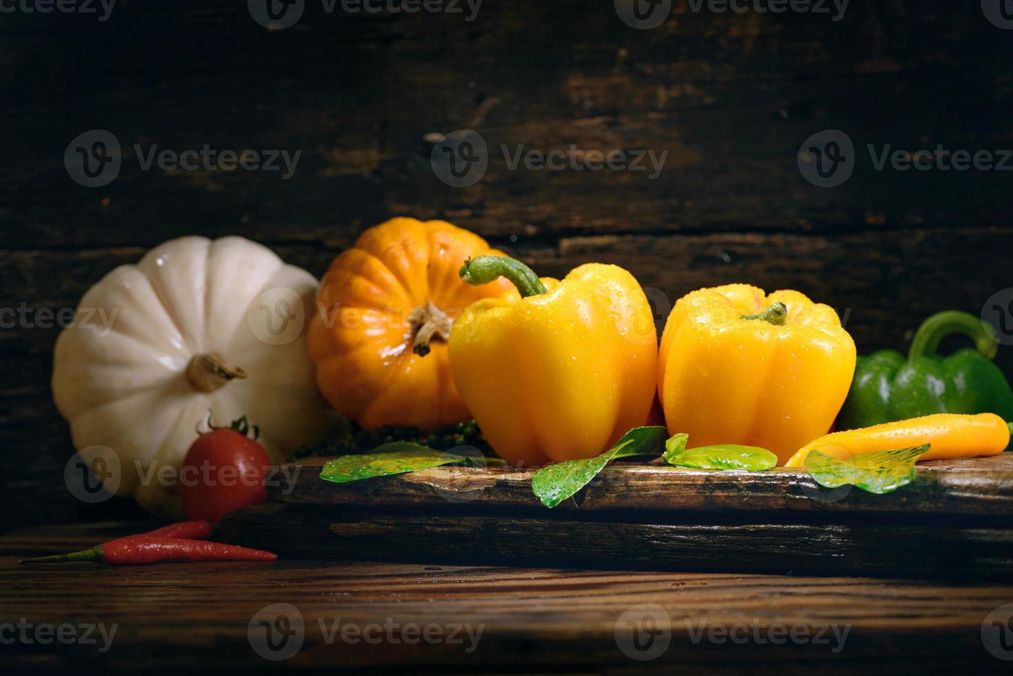 paprika med grönsaker på det gamla trägolvet foto