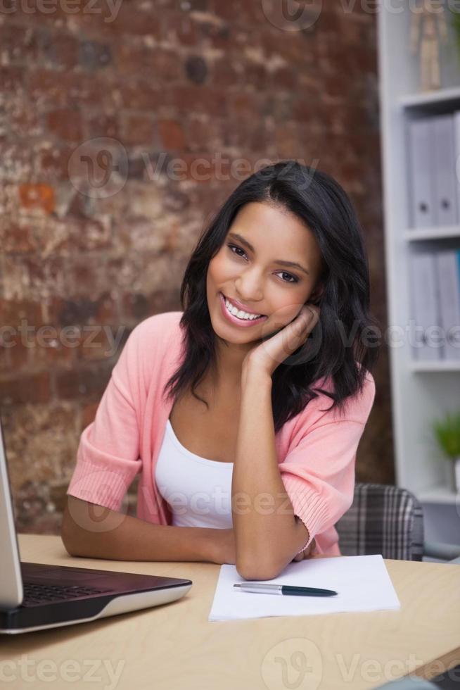 glad kvinna med sin bärbara dator som ler mot kameran foto