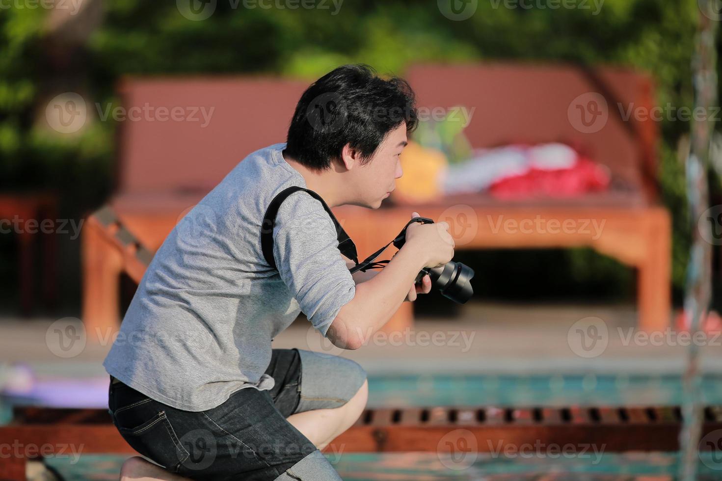 ögonblicket av asiatisk thai professionell fotograf ligger på knä och väntar på att ta ett fantastiskt foto. foto