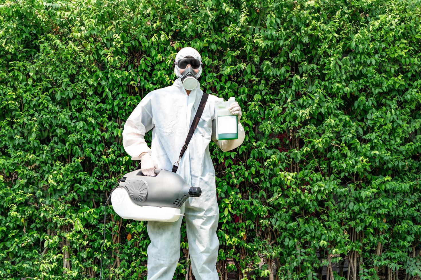 professionell teknisk man i förebyggande kostym och svarta glasögon med sin steriliseringsmaskin och desinficerande vatten i handen. han är redo att ta ut renande coronavirus covid19. foto
