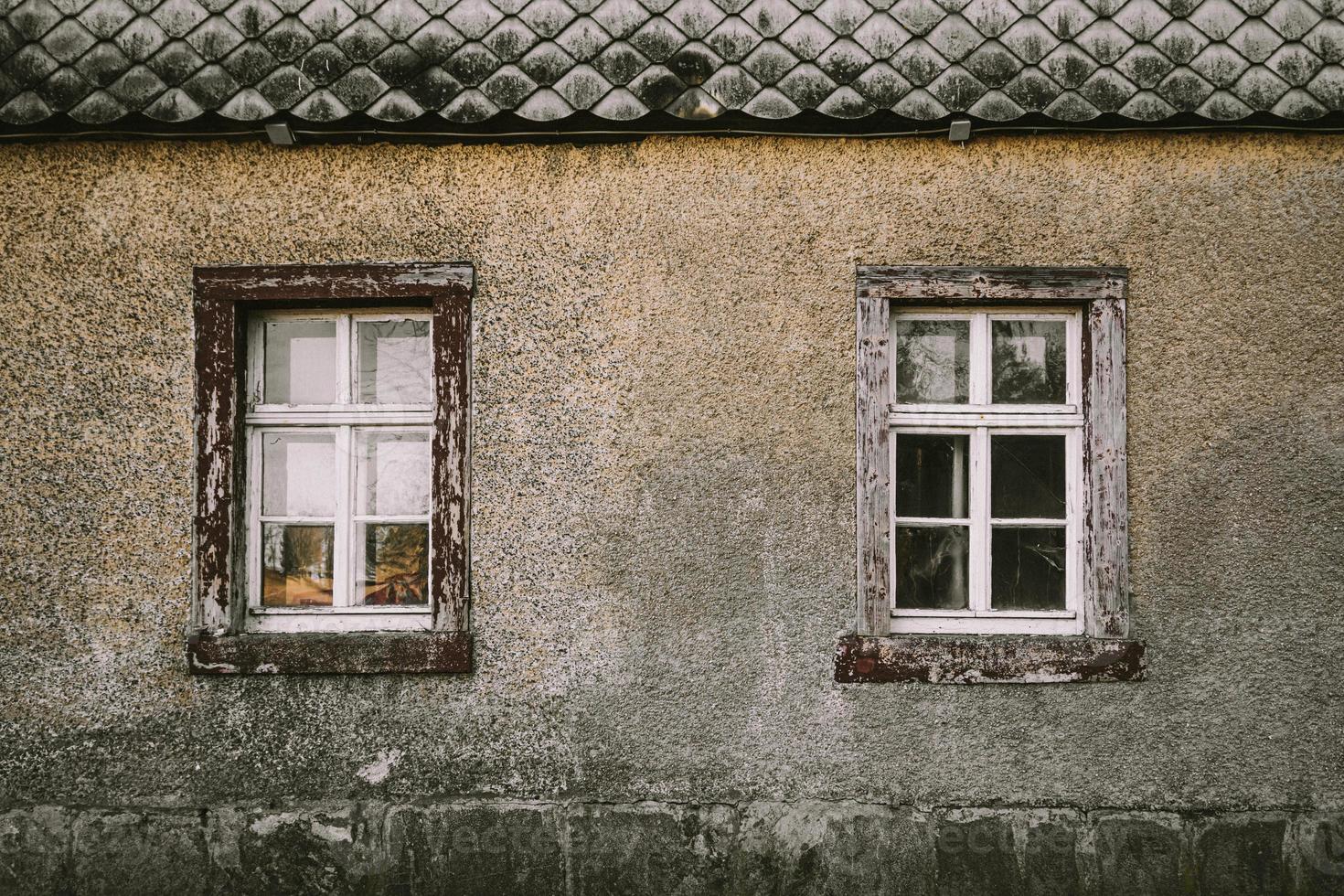 gammalt hus grå fasad med träfönster foto