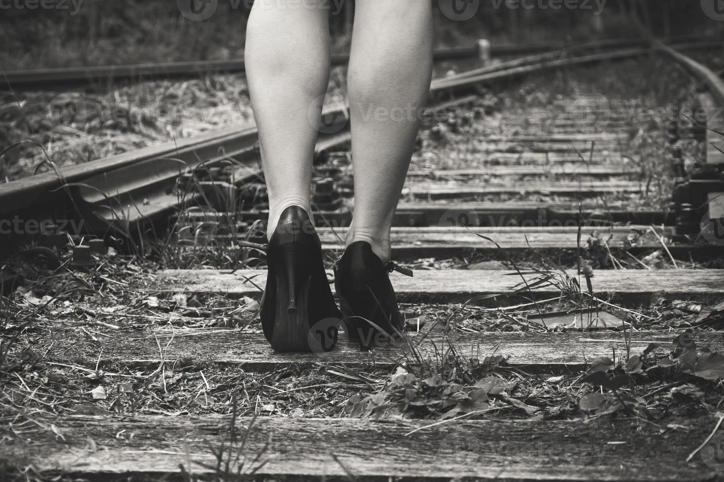 kvinna med höga klackar på ett järnvägsspår foto