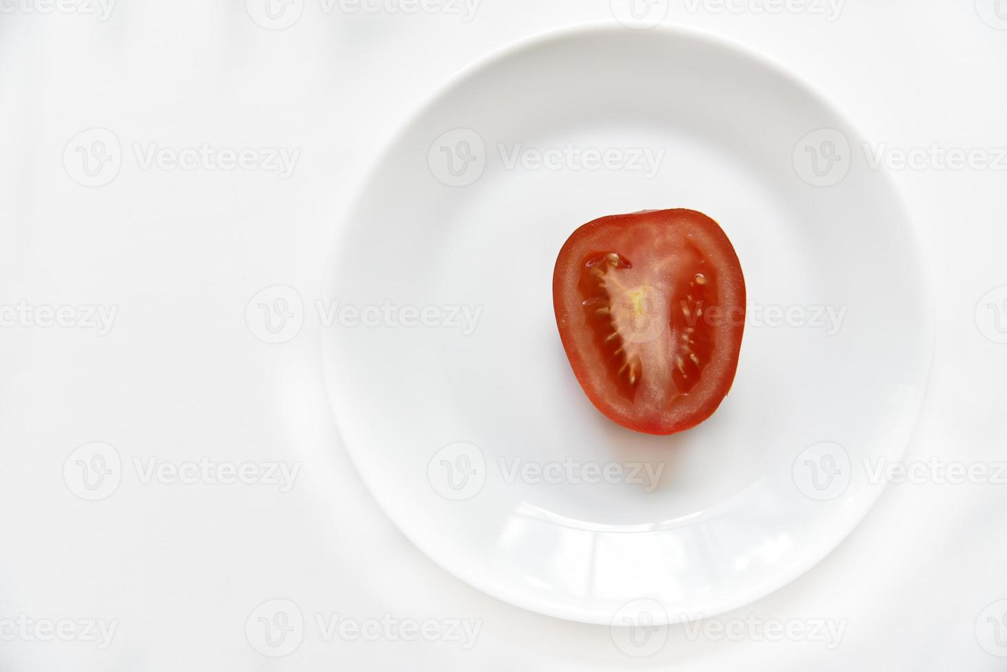 skivad röd tomat på en vit platta foto