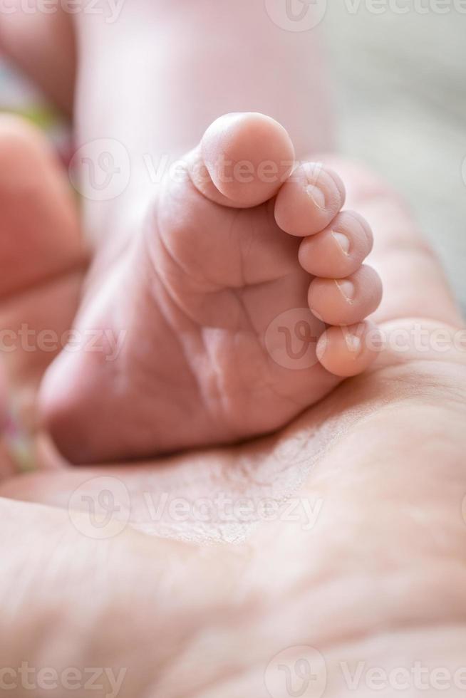 oskyldigt liv liten baby fot i handflatan av manlig hand foto