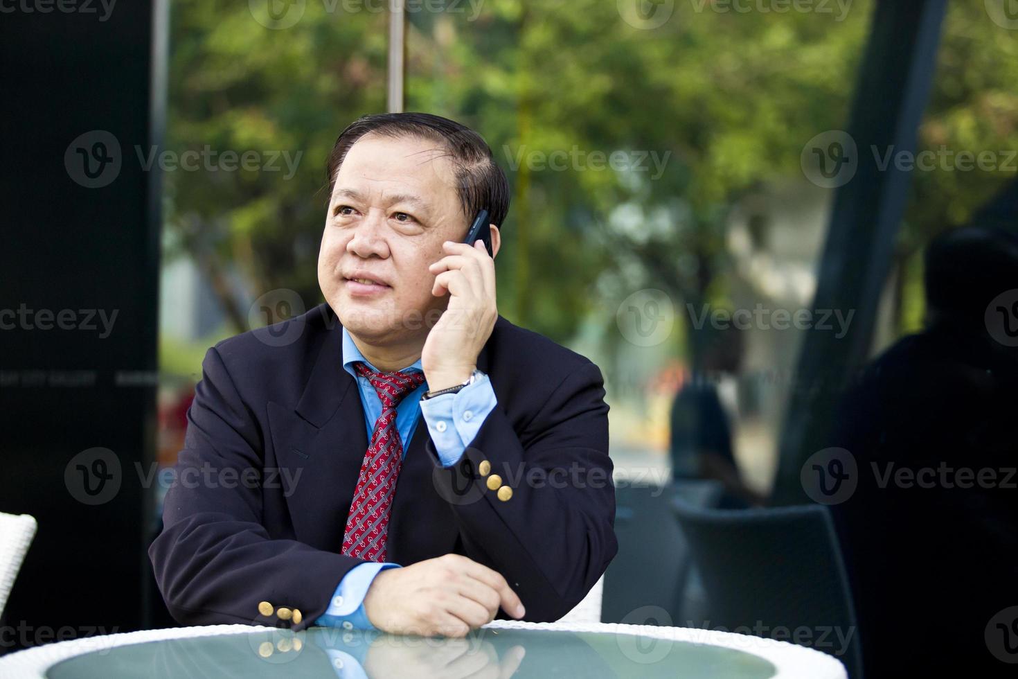 asiatisk affärsman som pratar på smart telefon foto