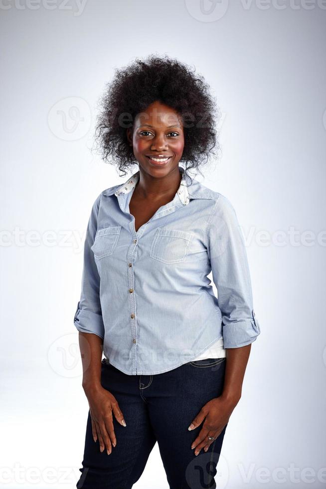 snygg afrikansk modell med lockigt hår poserar på vitt foto