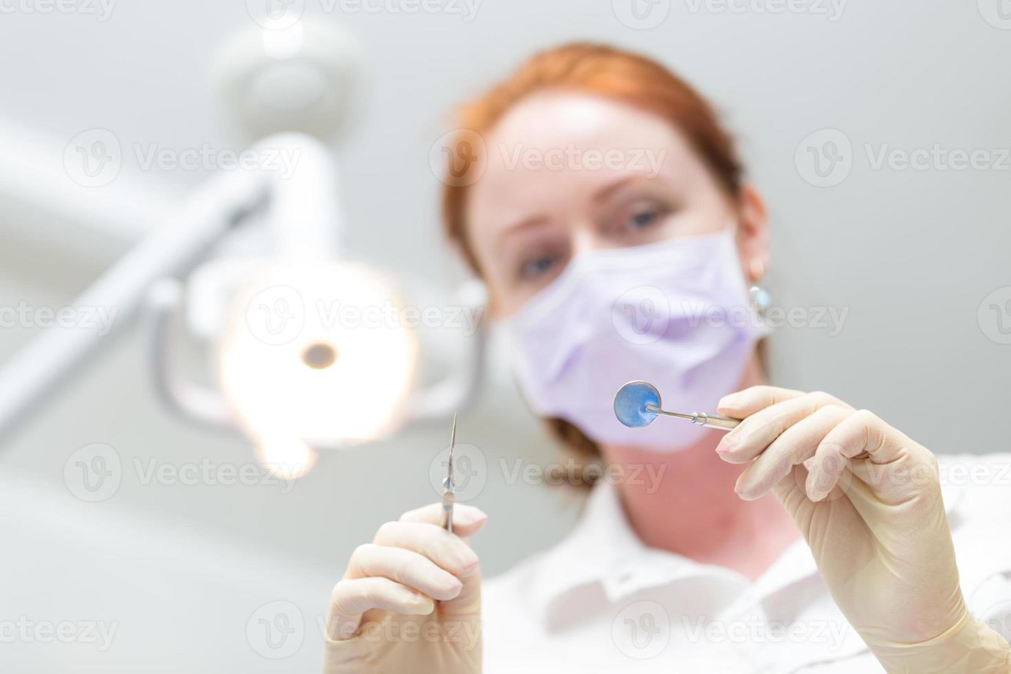 snäll tandläkare med spegel och sond närbild foto