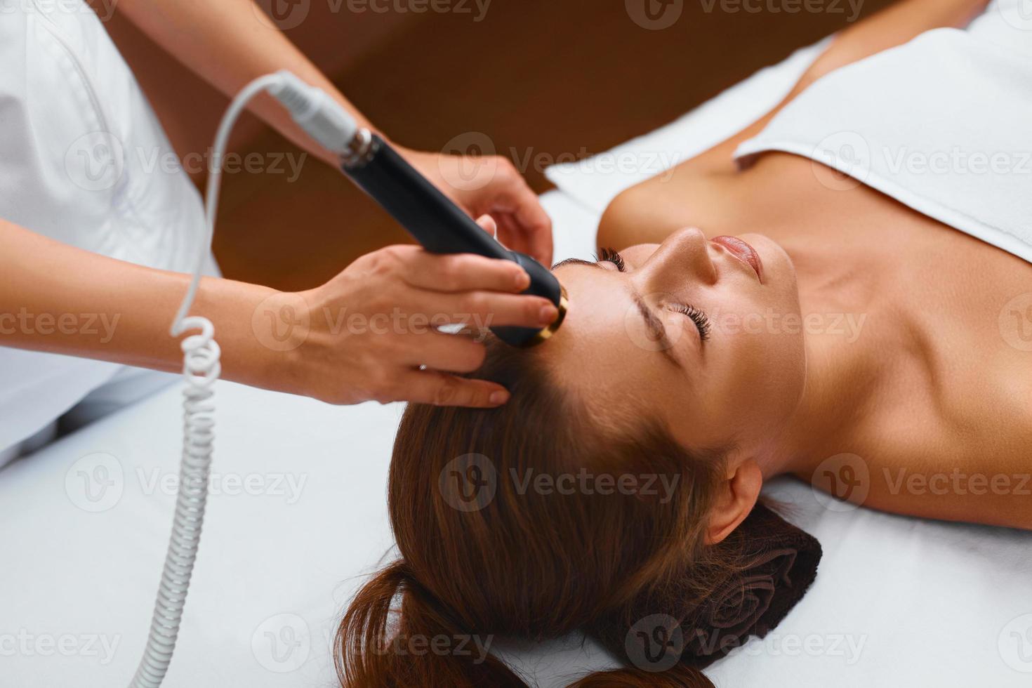 ansiktshudvård. kvinna i skönhet spa får en behandling foto