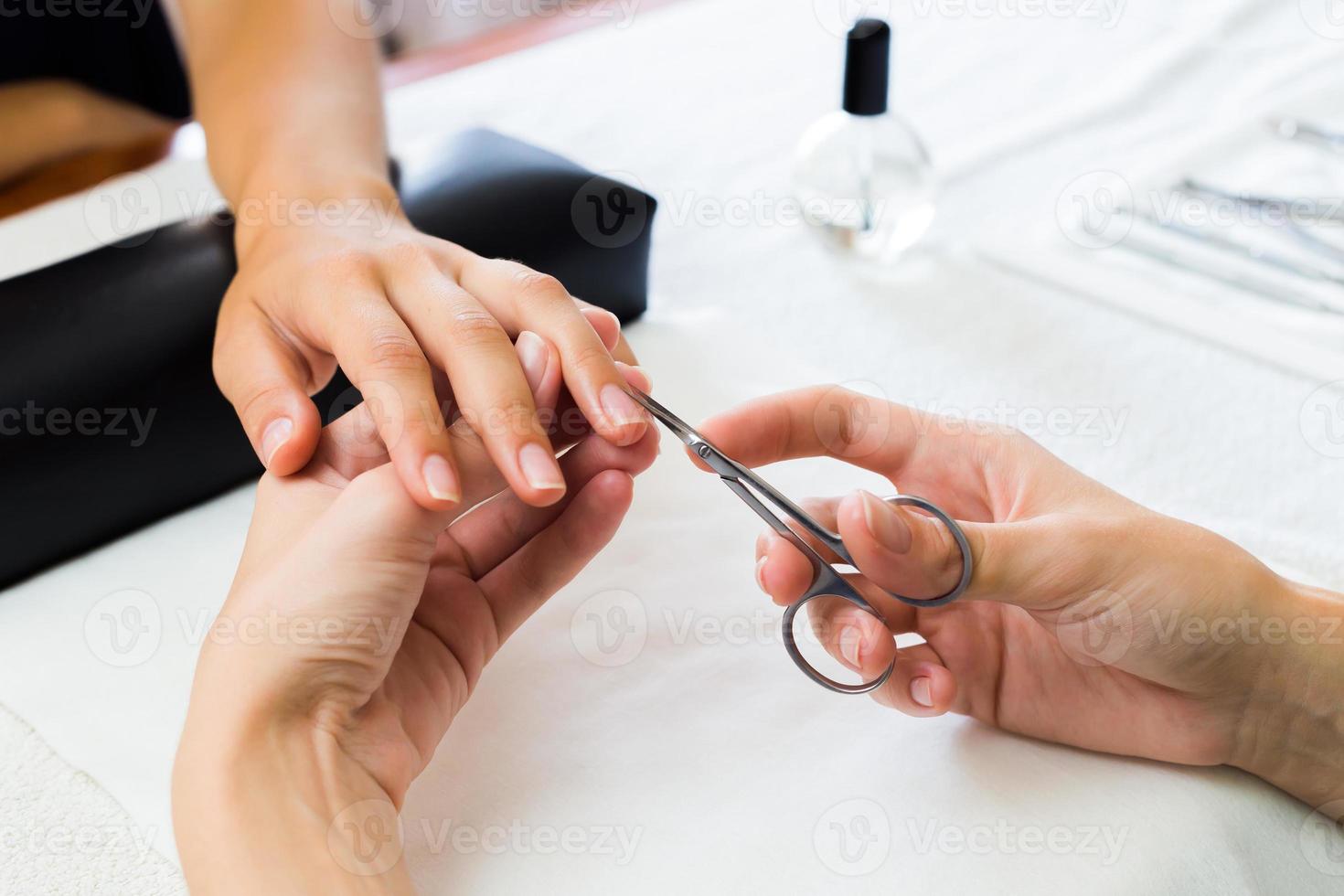manikyrist som klipper nagelband med klienter foto