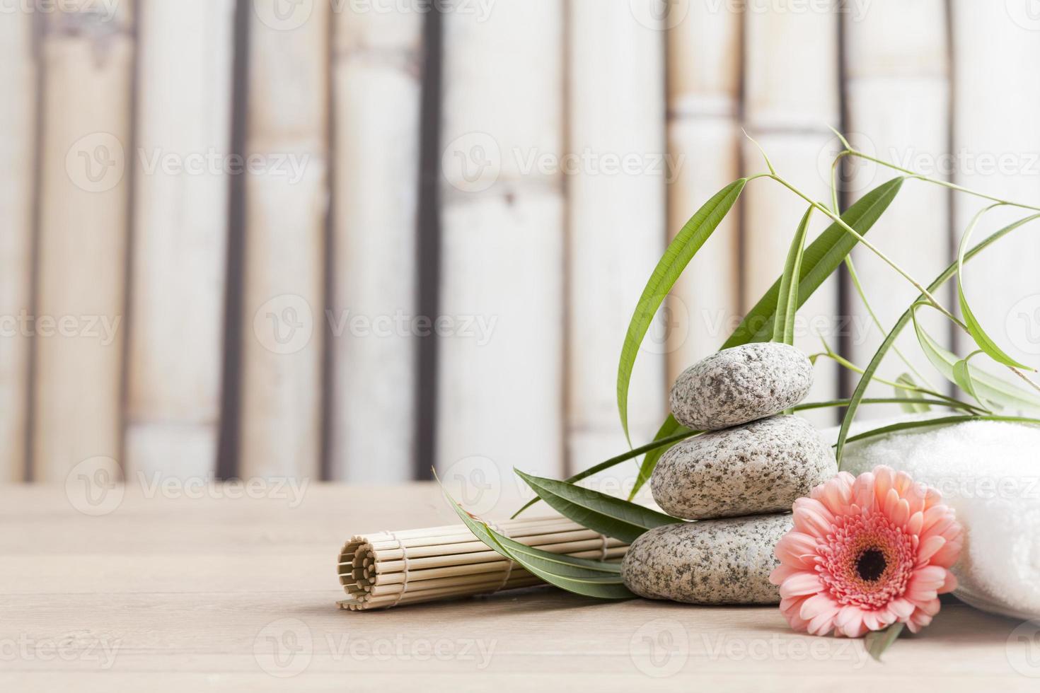 spa- och wellness-inställning med blommor, zenstenar och handduk foto