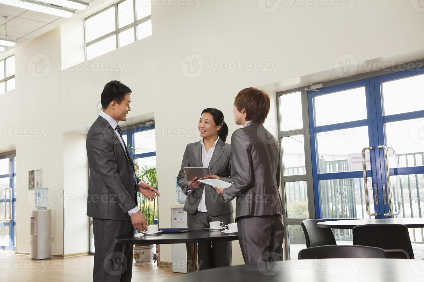 tre affärsmän som möts i företagets cafeteria foto