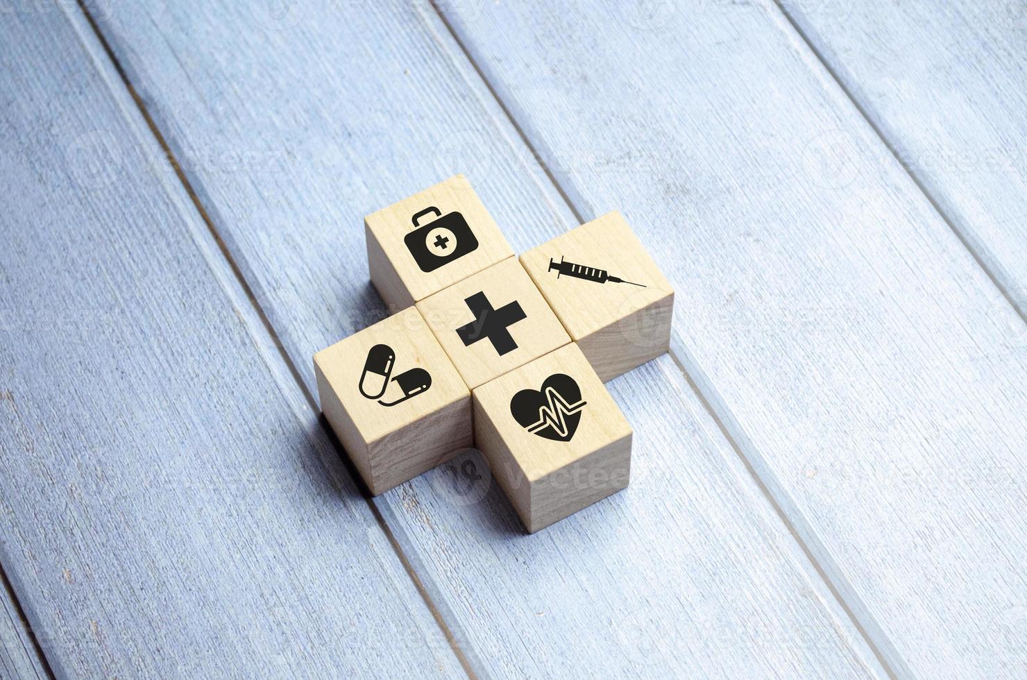 sjukförsäkring koncept, träblock med sjukvård medicinsk ikon, blå bakgrund foto