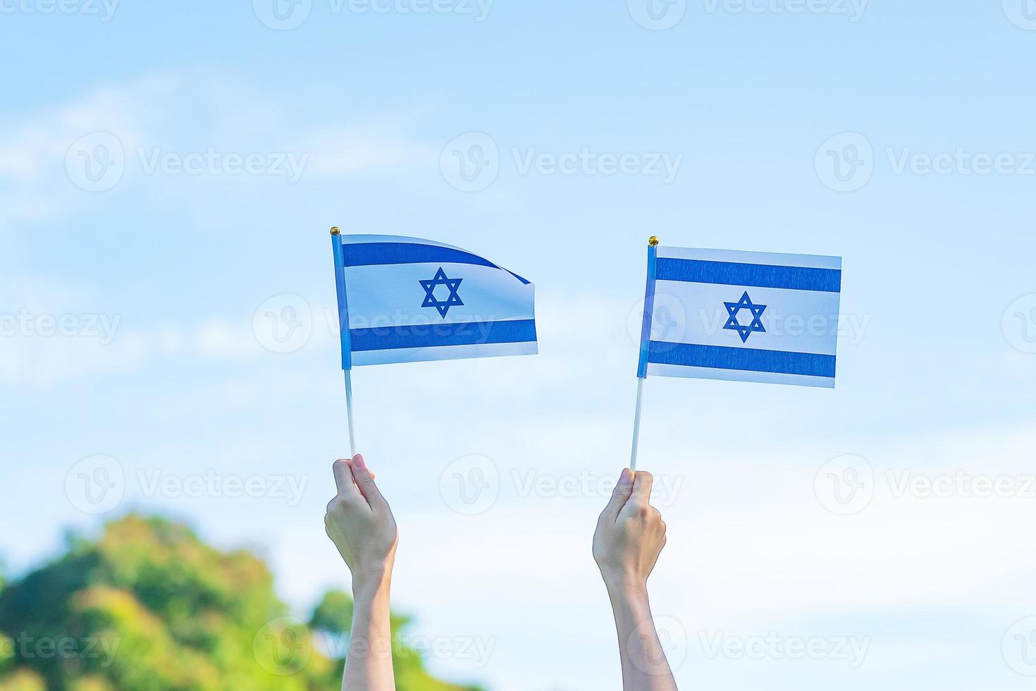 hand som håller Israels flagga på naturbakgrund. Israels självständighetsdag och glada festkoncept foto