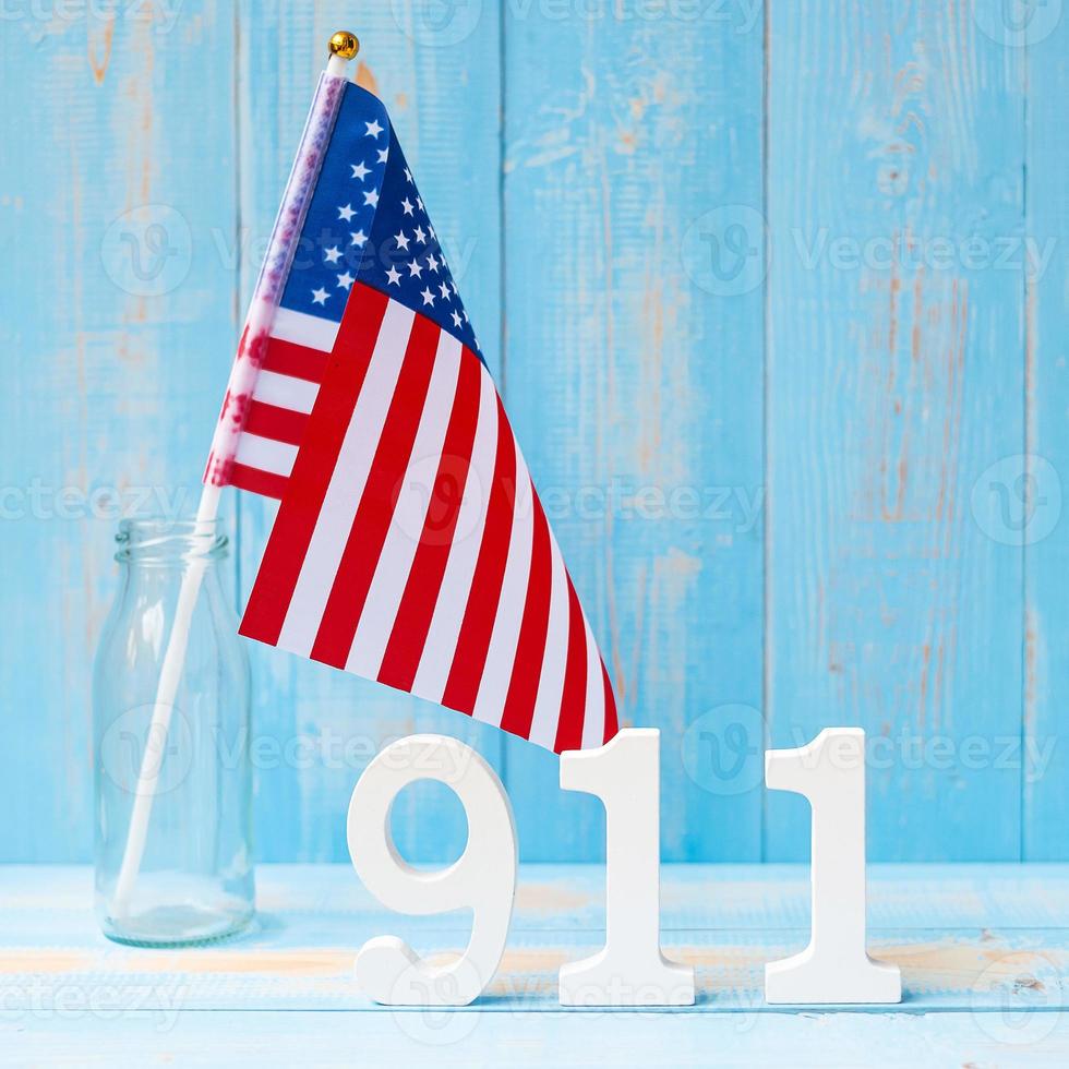 911 text och USA flagga på träbord bakgrund. Patriotdagen, september, minnesmärke och glöm aldrig koncept foto