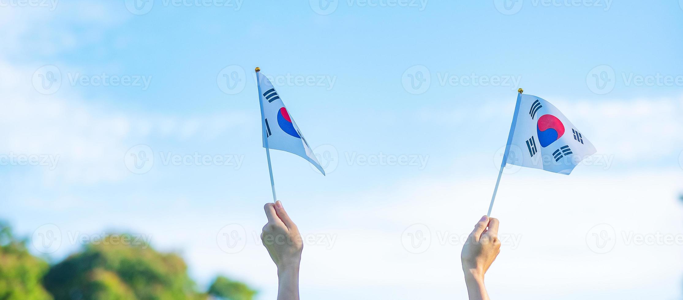 hand som håller korea flaggan på natur bakgrund. national foundation, gaecheonjeol, allmän nationshelgdag, Koreas nationella befrielsedag och glada firandekoncept foto