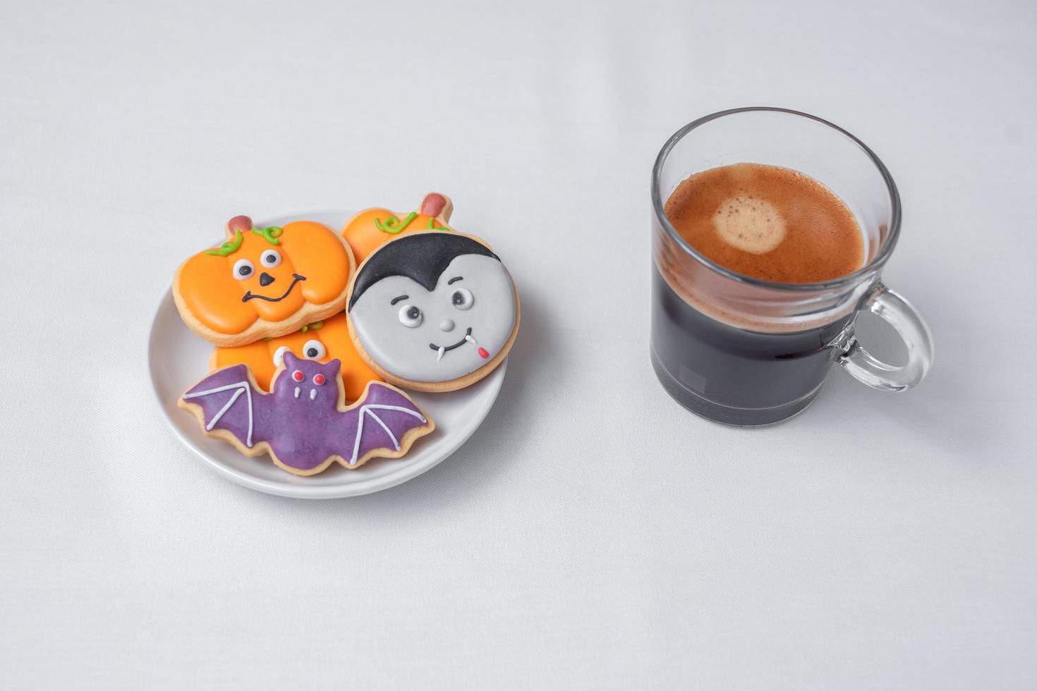 hett espressokaffe eller chokladkopp med roliga halloweenkakor. glad halloween dag, trick eller hot, hej oktober, höst höst, traditionell, fest och semester koncept foto