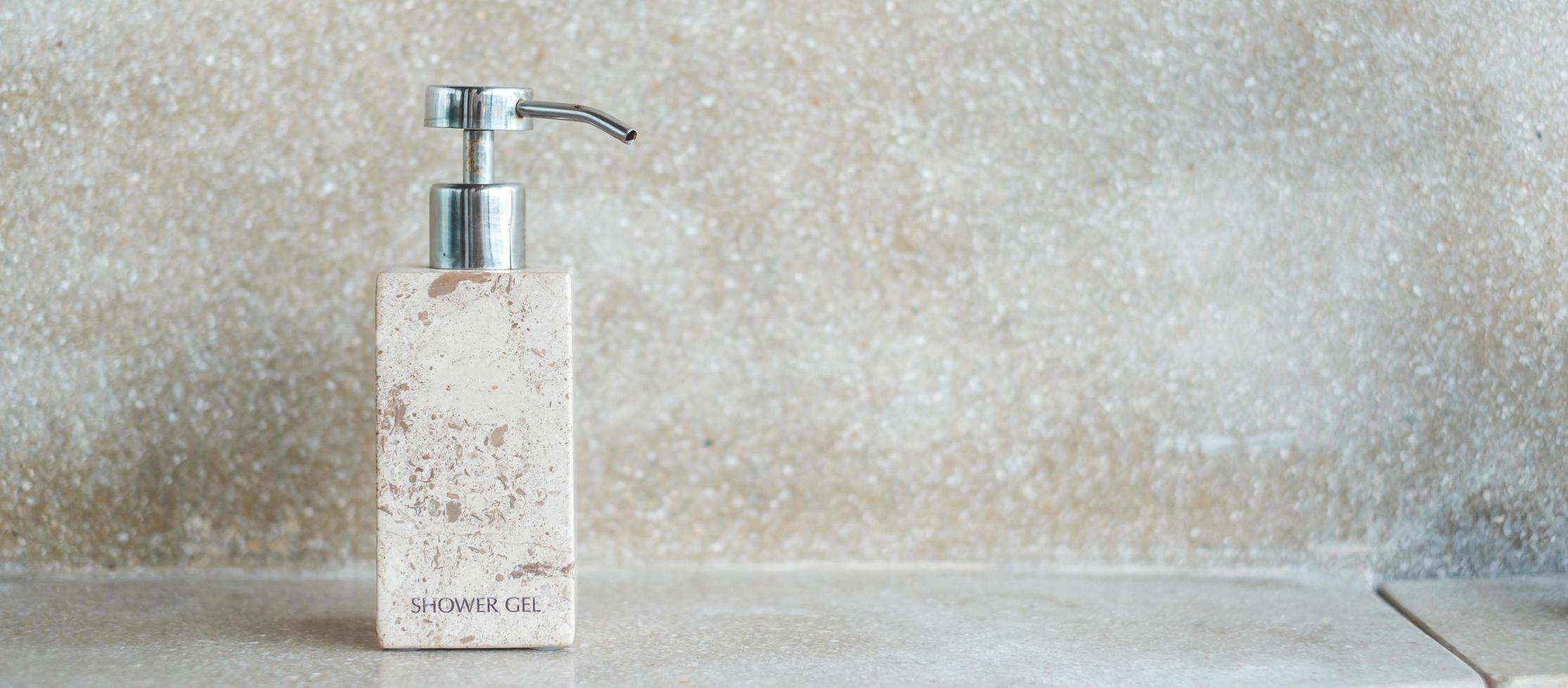 toalettartiklar flaskor i badrummet på lyxhotell eller moderna hem. body shower gel i keramik med väggbakgrund foto