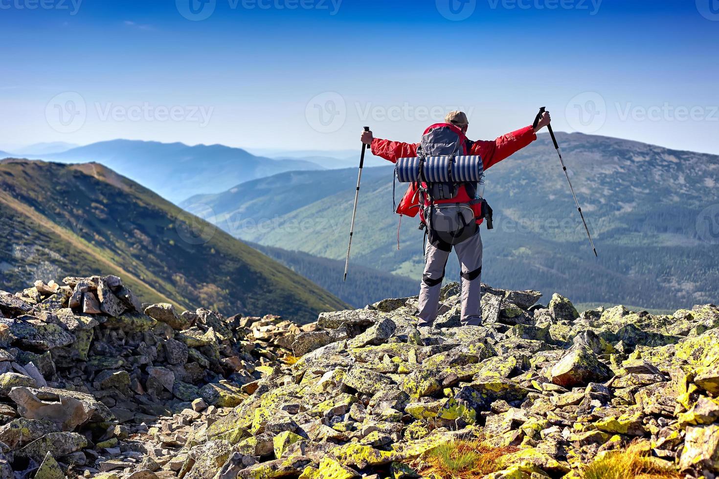 vandrare med ryggsäck som står i bergen och njuter av v foto