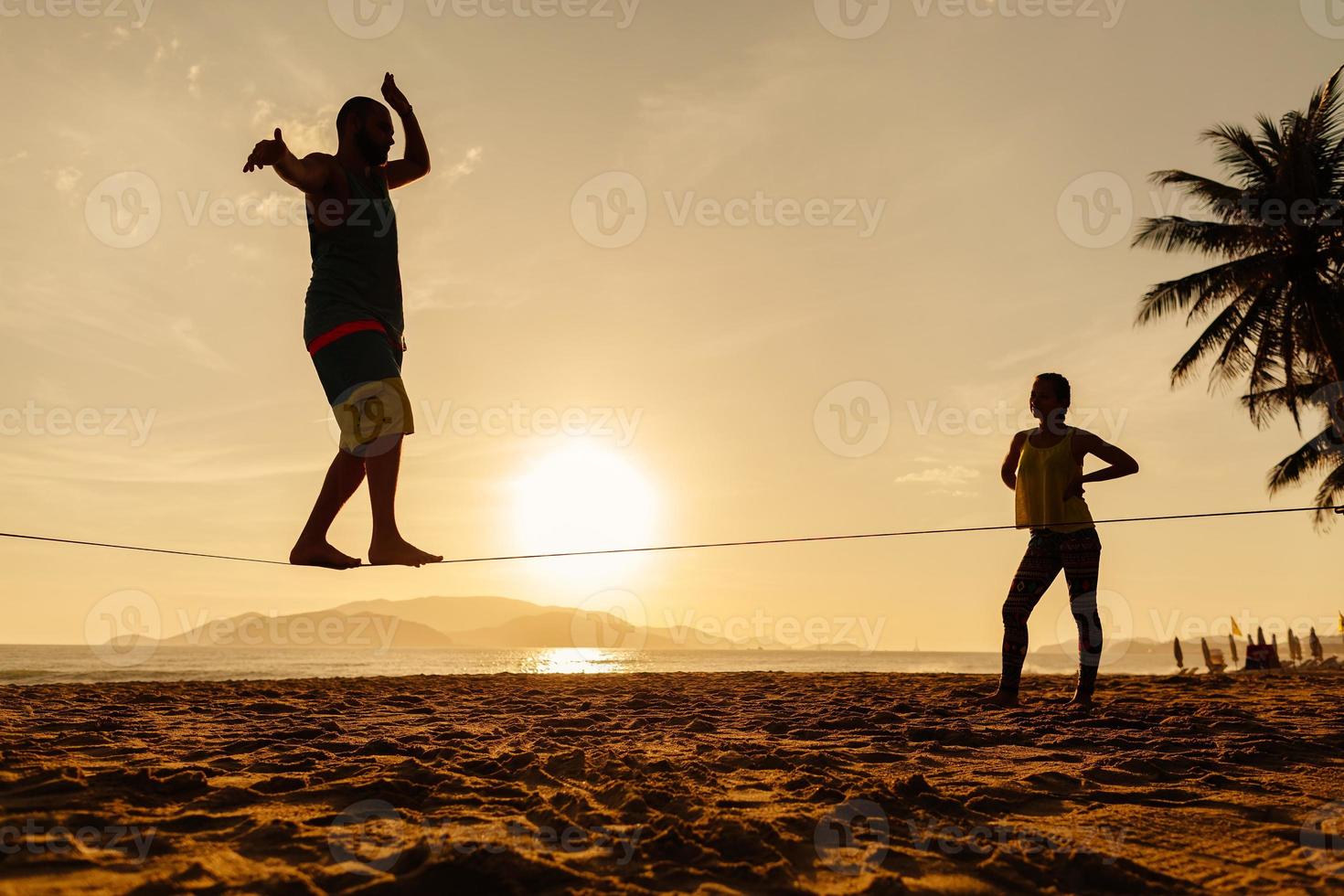 tonåringar balanserar på slackline silhuetten foto