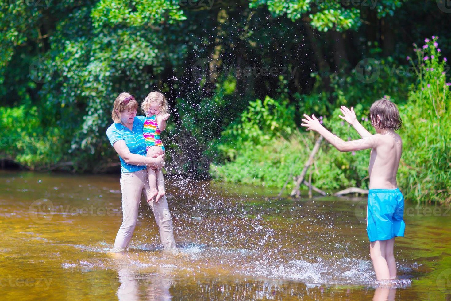 familjen njuter av varm dag på en flod foto
