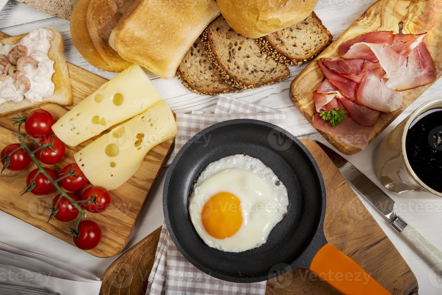 stekt ägg i panna, ost, skinka, bröd och bullar foto