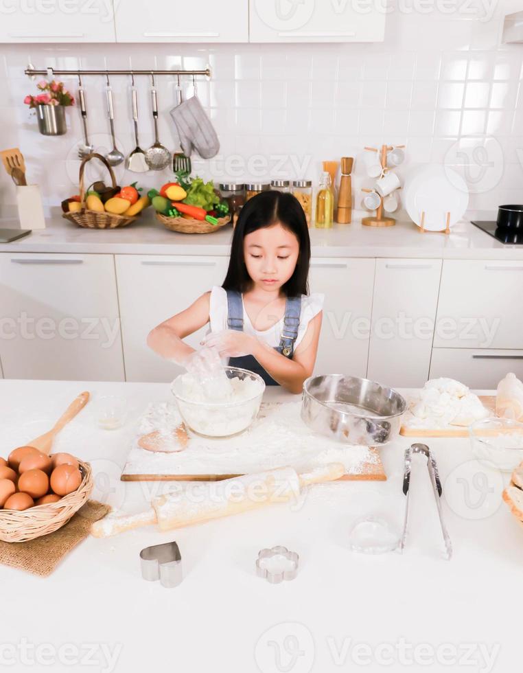 lyckligt litet barn förbereda en baka i köket foto