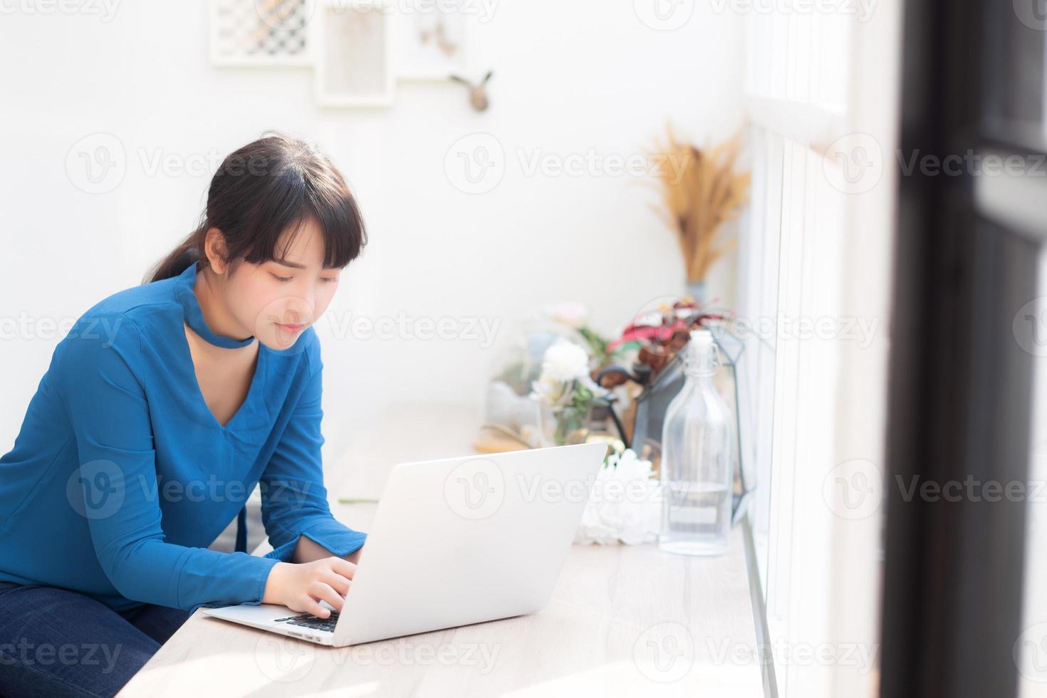 vackert porträtt asien ung kvinna som arbetar online på bärbar dator sitter på café butik, professionell kvinnlig frilans med bärbar dator, affärs- och kommunikationskoncept. foto
