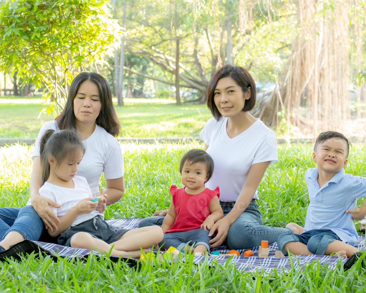 vackra unga asiatiska föräldrar familj porträtt picknick i parken, barn eller barn och mamma älskar glada och glada tillsammans på sommaren i trädgården, livsstilskoncept. foto