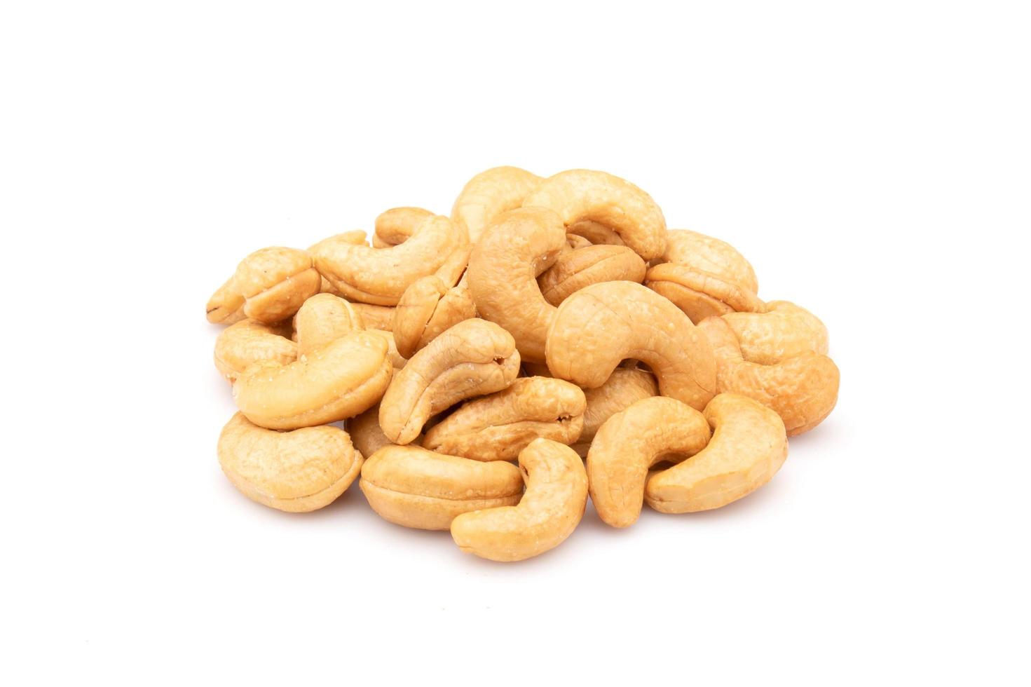 hög med rostad cashewnötter isolerad på vit bakgrund. mat koncept foto
