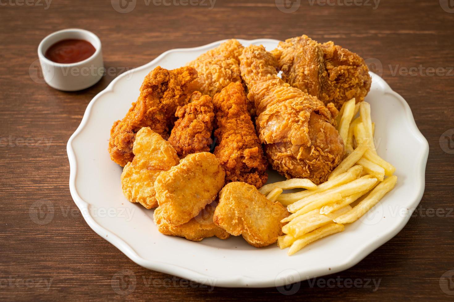 stekt kyckling med pommes frites och nuggets på tallrik foto