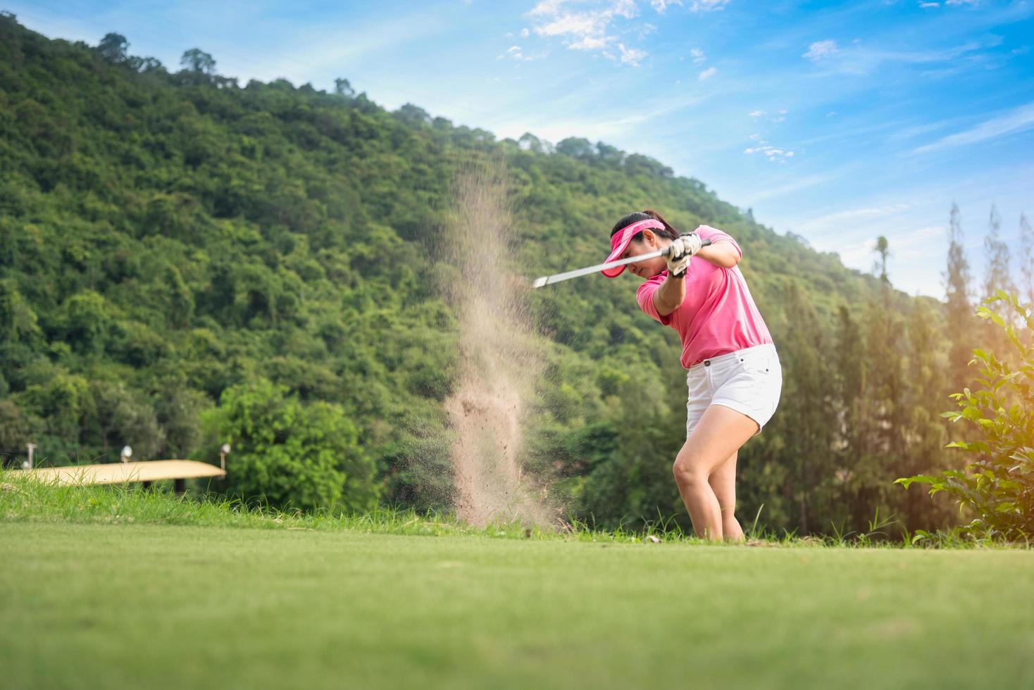 unga kvinnor spelare golf swing skott på kurs i morgon soluppgång foto