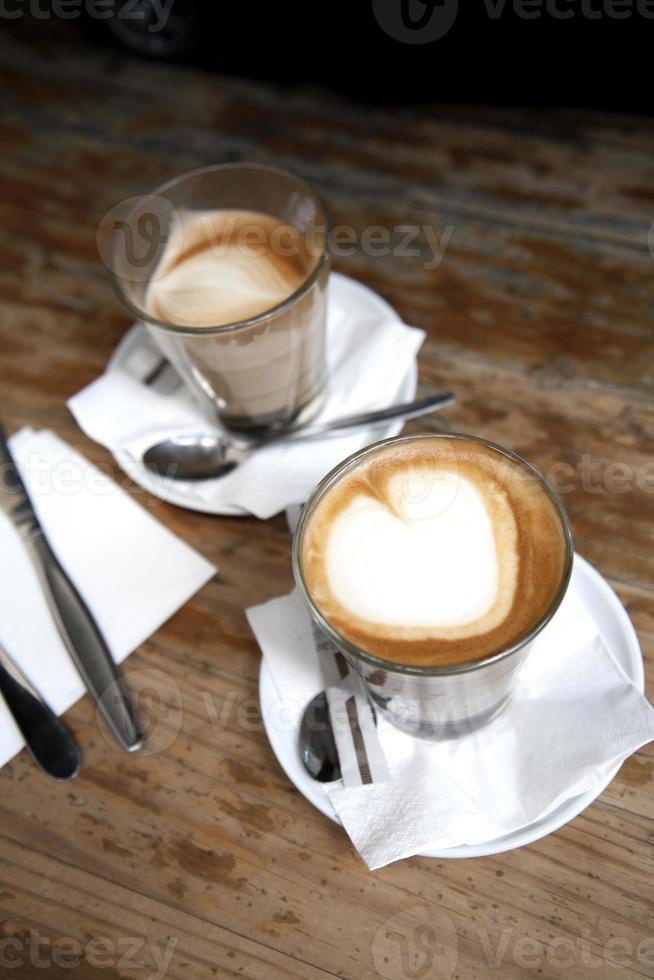 kaffe och bestick med hjärtformad skum foto