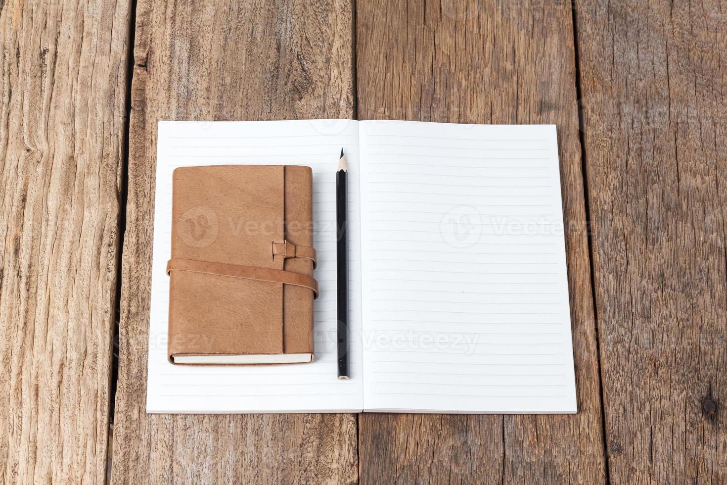 tom öppet anteckningsbok med svart penna på träbord foto